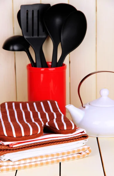 Kök inställningar: redskapen, Grytlappar, handdukar och annat på träbord — Stockfoto