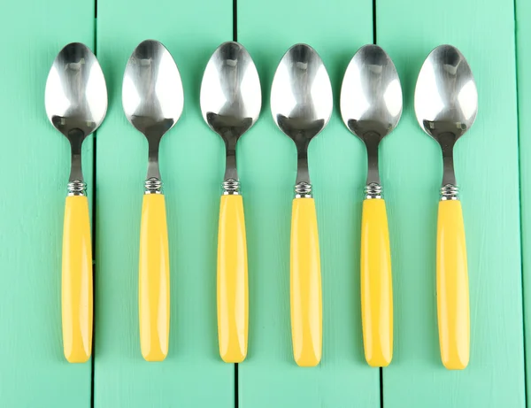 Dessert spoons on color wooden background — Stock Photo, Image