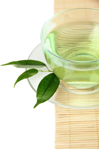 Transparent cup of green tea on bamboo mat, isolated on white — Stock Photo, Image