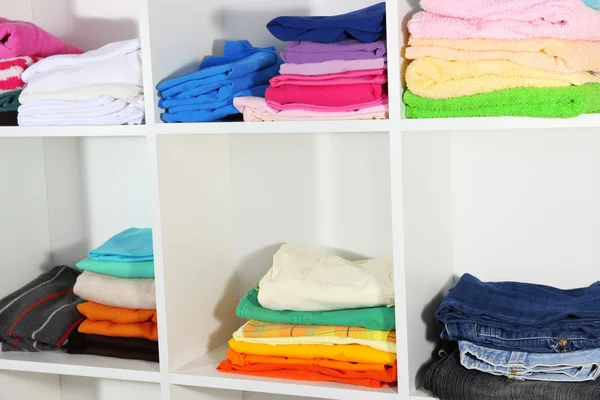 Clothes neatly folded on shelves — Stok fotoğraf