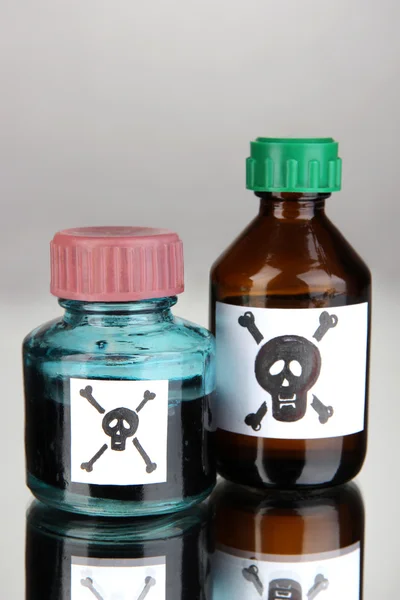 Veneno mortal em garrafas em fundo cinza — Fotografia de Stock