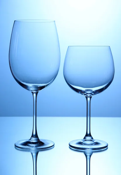 Copos de vinho vazios dispostos em fundo azul — Fotografia de Stock