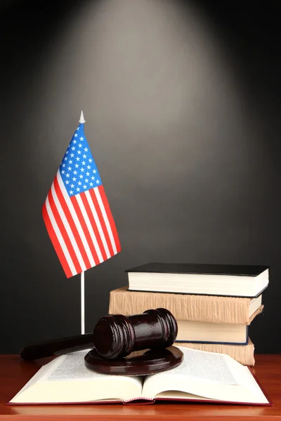 Wooden gavel, books and American flag on grey background — Stock Photo, Image