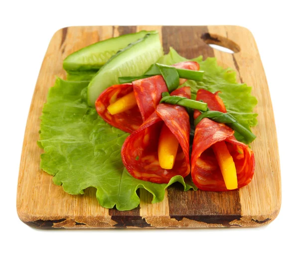 Salami rolls with paprika pieces inside, on wooden board, isolated on white — Stock Photo, Image