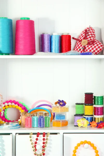 Beautiful white shelves with thread and material for handicrafts — Stock Photo, Image