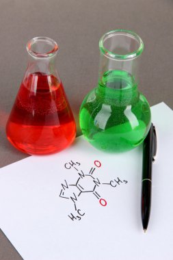 test tüpleri ile renkli sıvılar ve formüllerini gri arka plan üzerinde