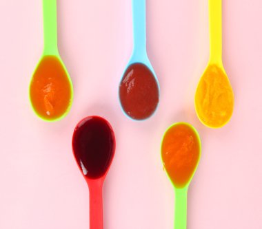 Bebek püresi pembe bir arka plan üzerine kaşık içinde