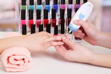 Manicure process in beauty salon, close up clipart