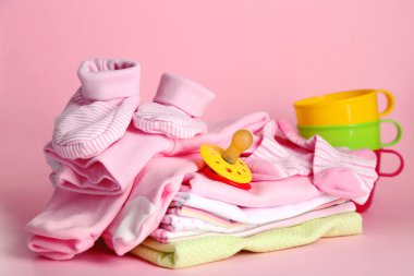 pembe bir arka plan üzerinde bebek elbise yığını