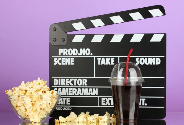 Film clapperboard, cola et pop-corn sur fond violet — Photo