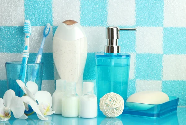 Accesorios de baño en el estante en el baño sobre fondo de pared de azulejo azul —  Fotos de Stock