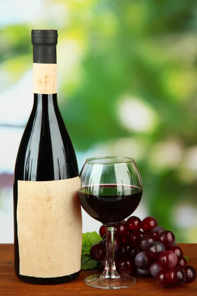 Composição de garrafa de vinho, vidro e uva, sobre fundo brilhante — Fotografia de Stock