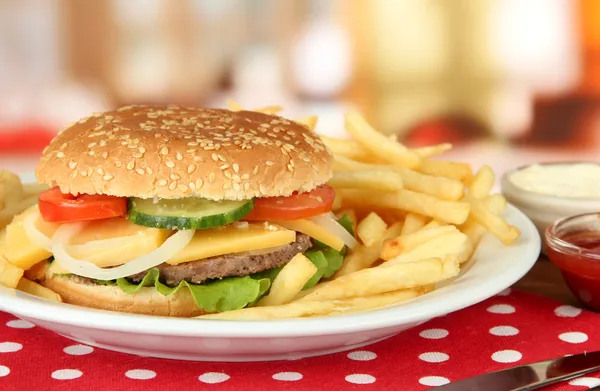 Смачний чізбургер зі смаженою картоплею на яскравому фоні — стокове фото