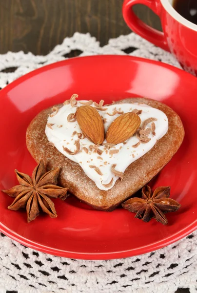 Chocolate cookie in form of heart with cup of coffee on wooden table close-up — Stock Photo, Image