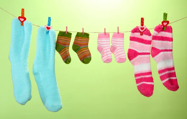 Chaussettes colorées suspendues sur corde à linge, sur fond de couleur — Photo