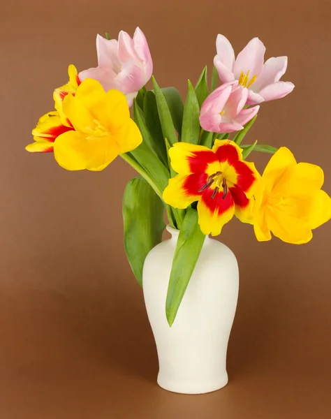 Schöne Tulpen im Eimer auf braunem Hintergrund — Stockfoto