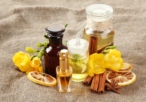 Flessen met ingrediënten voor het parfum op jute achtergrond — Stockfoto