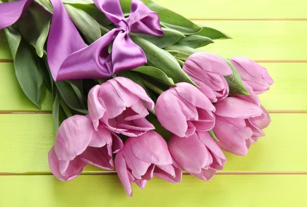 Beau bouquet de tulipes violettes sur fond de bois vert — Photo