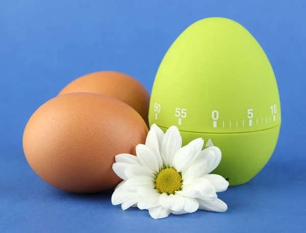 Temporizador de ovo verde e ovos, em fundo de cor — Fotografia de Stock