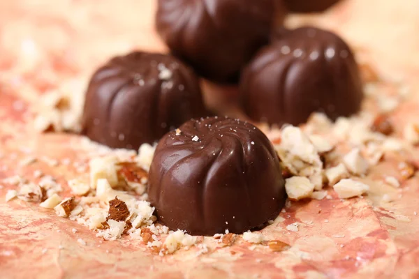 Chocolade snoepjes met noten, op een achtergrond met kleur — Stockfoto