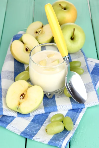 Delicious yogurt in glass with fruit on wooden table close-up — Stock Photo, Image