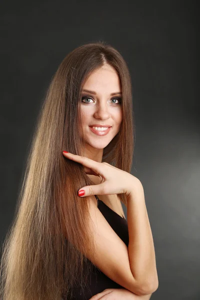 Portrait of beautiful woman with long hair on black background — Stock Photo, Image
