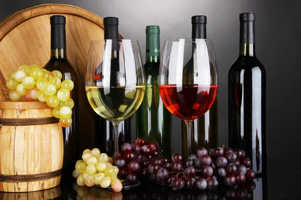 Weinsortiment in Gläsern und Flaschen auf grauem Hintergrund — Stockfoto