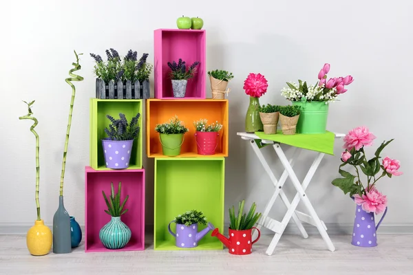 Prateleiras coloridas bonitas com elementos decorativos em pé no quarto — Fotografia de Stock