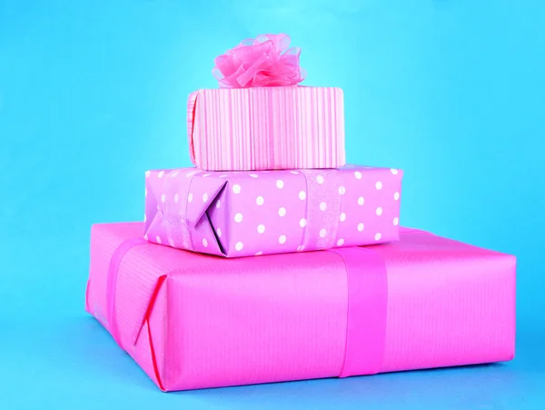 Yay üzerinde mavi arka plan ile parlak hediyeler — Stok fotoğraf