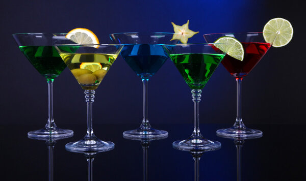 Alcoholic cocktails in martini glasses on dark blue background