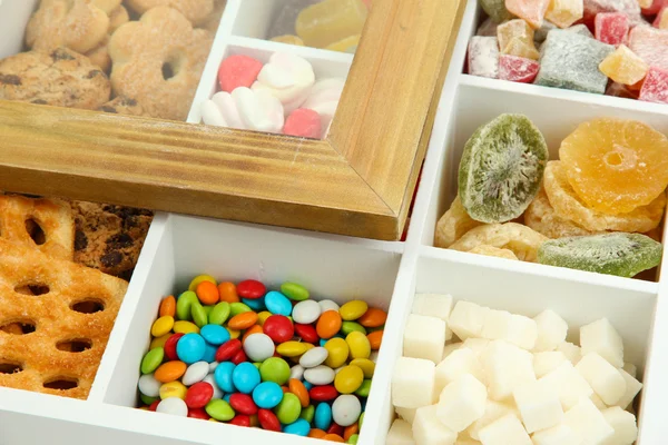 Багатобарвні цукерки та печиво в білій дерев'яній коробці крупним планом — стокове фото