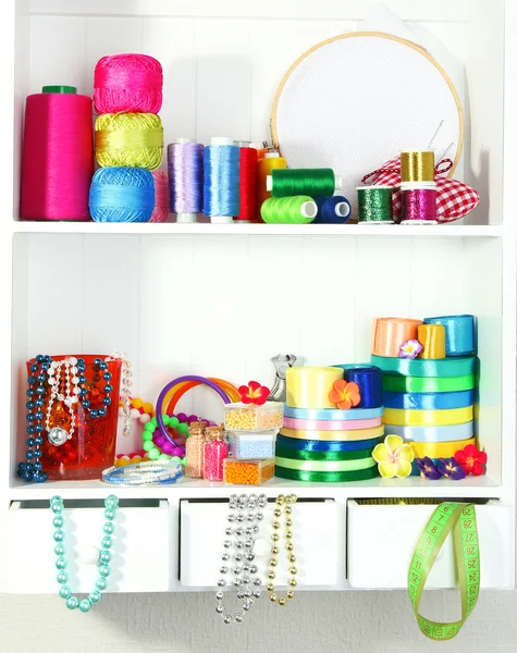 Beautiful white shelves with thread and material for handicrafts — Stockfoto