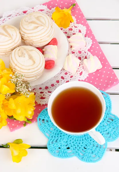 Beautiful composition with cup of tea and marshmallow on wooden picnic table close-up — Stock Photo, Image