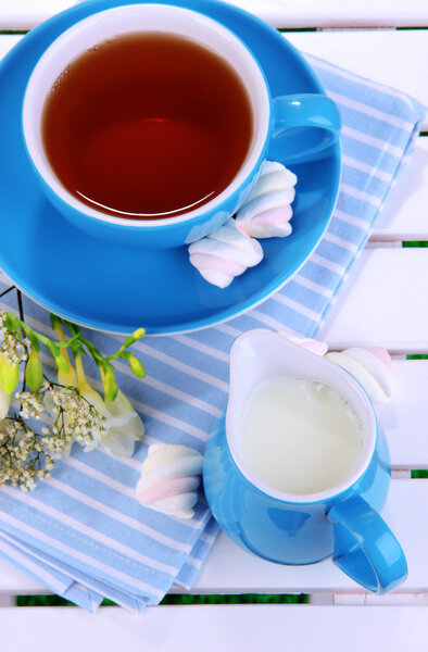 Beautiful tea composition on wooden picnic table close-up