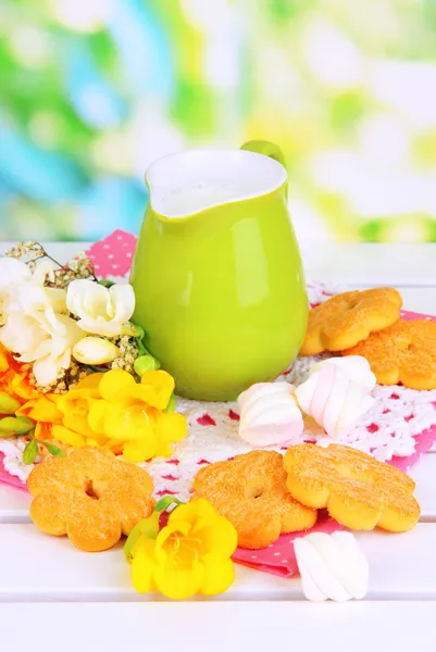 Vackra sammansättningen av mjölk och kakor på trä picknickbord på naturliga bakgrund — Stockfoto