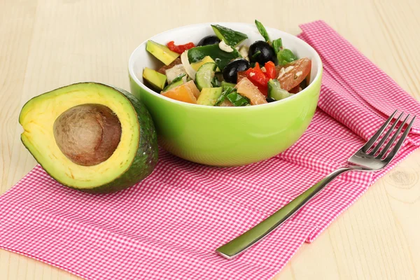 Sabrosa ensalada de aguacate en tazón sobre mesa de madera de cerca — Foto de Stock