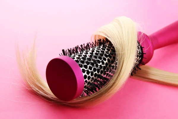 Spazzola pettine con i capelli, su sfondo rosa — Foto Stock