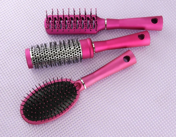 Comb brushes on purple background — Stockfoto