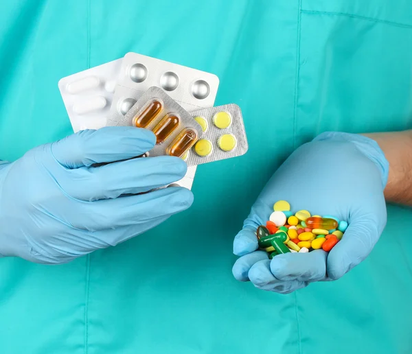 Doctor gives many different pills, on blue background — Stock Photo, Image