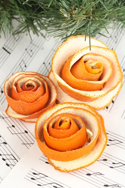 Decoratieve rose van droge sinaasappelschil op muzieknoten — Stockfoto