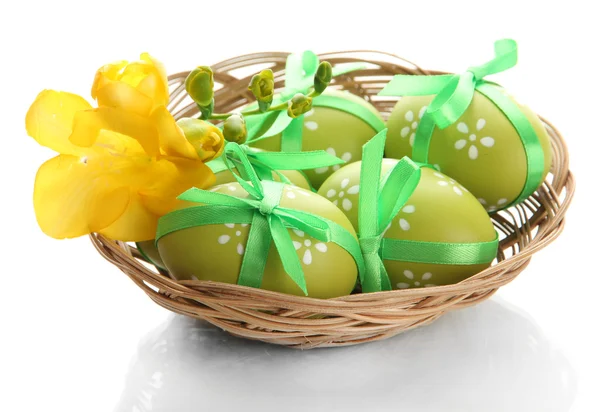 Huevos de Pascua brillantes con arcos en cesta, aislados en blanco —  Fotos de Stock