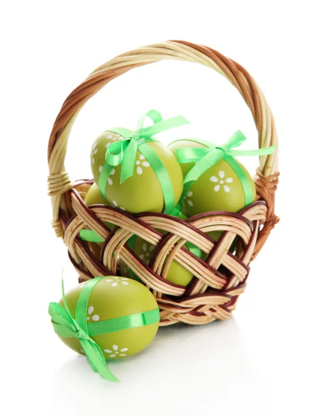 Luminose uova di Pasqua con fiocchi in cesto, isolate su bianco — Foto Stock