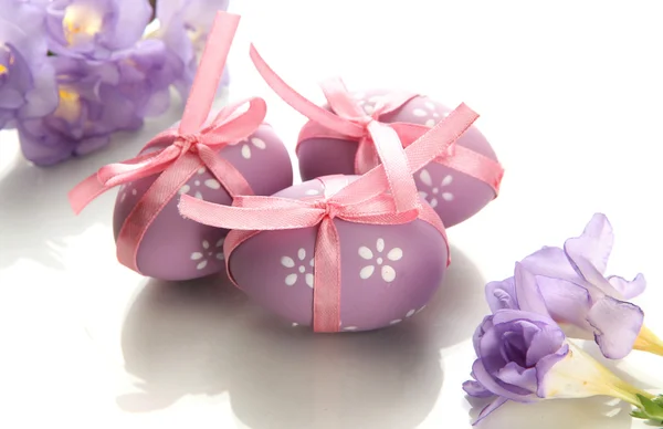 Luminose uova di Pasqua con fiocchi e fiori, isolate su bianco — Foto Stock