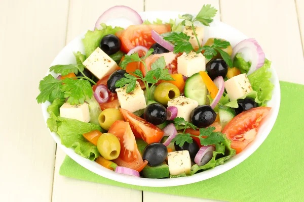 Insalata fresca in piatto su tavolo di legno — Foto Stock