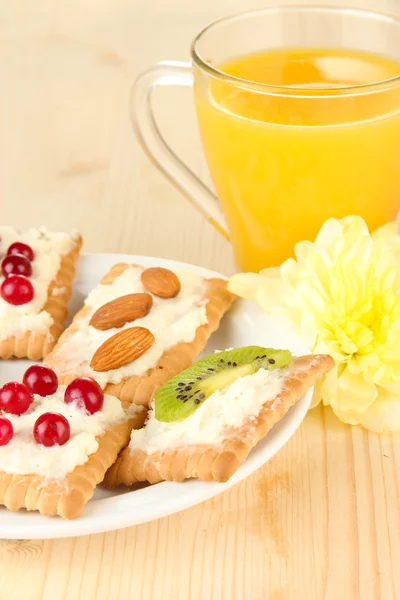 Canapés saborosos com queijo, kiwi e cranberry, amêndoa, na placa de cor, no fundo de madeira — Fotografia de Stock