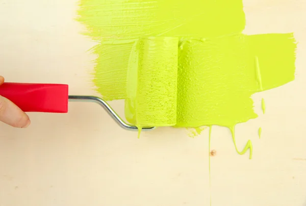 Rulo fırça ahşap zemin üzerine yeşil boya ile boyayın. — Stok fotoğraf