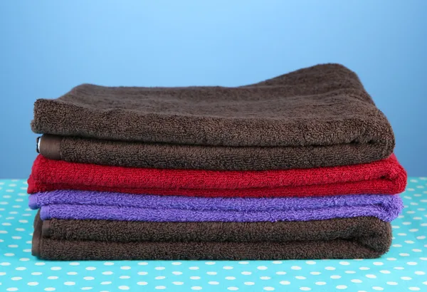 Pilha de toalhas coloridas, sobre fundo azul — Fotografia de Stock