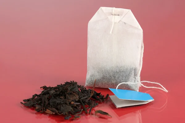 Çay torba kırmızı zemin üzerine — Stok fotoğraf