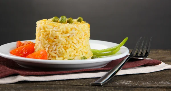 Heerlijke risotto met groenten op houten tafel, op grijze achtergrond — Stockfoto