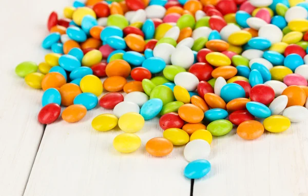 Kolorowe cukierki na białym tle drewniane — Zdjęcie stockowe